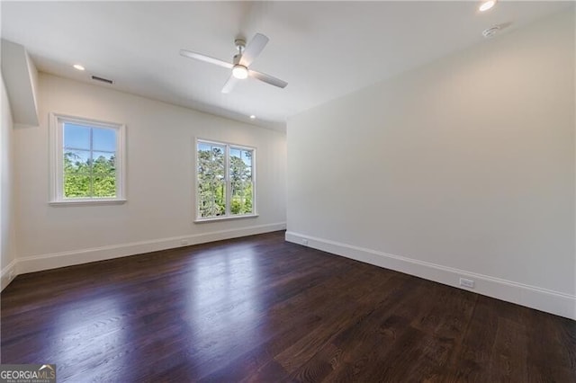 empty room with ceiling fan, dark hardwood / wood-style flooring, and a healthy amount of sunlight