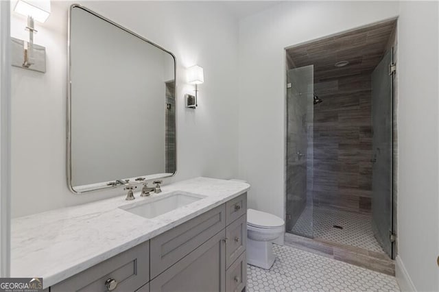 bathroom with vanity, toilet, tile patterned floors, and a tile shower