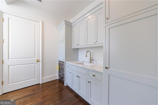 laundry area with sink, wine cooler, and dark hardwood / wood-style flooring