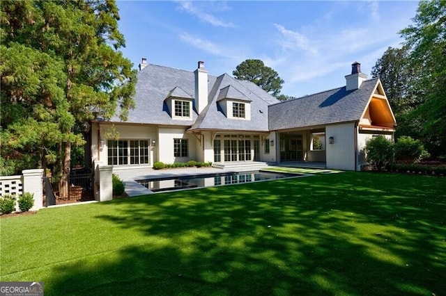 rear view of house with a lawn and a patio area