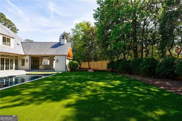 view of yard with a fenced in pool and a patio