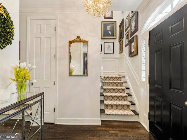 entrance foyer with crown molding, an inviting chandelier, and hardwood / wood-style floors