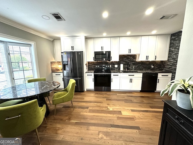 kitchen featuring appliances with stainless steel finishes, white cabinetry, sink, and wood-type flooring