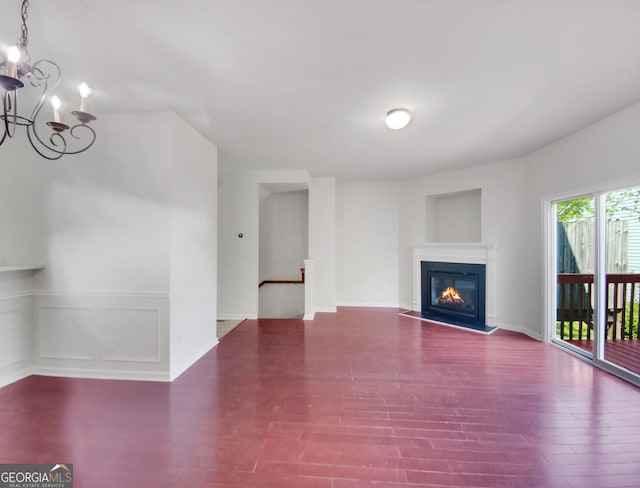 unfurnished living room featuring hardwood / wood-style floors and a chandelier