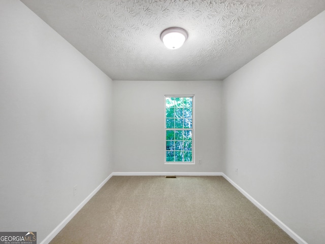 empty room with a textured ceiling and carpet floors