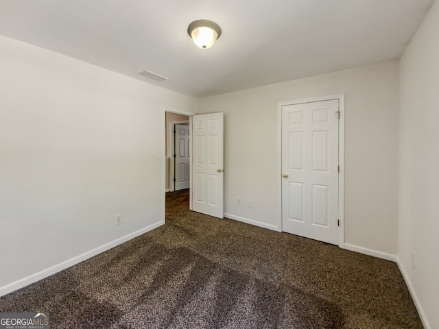 unfurnished bedroom featuring dark colored carpet