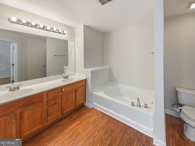 bathroom with wood-type flooring, oversized vanity, toilet, and double sink