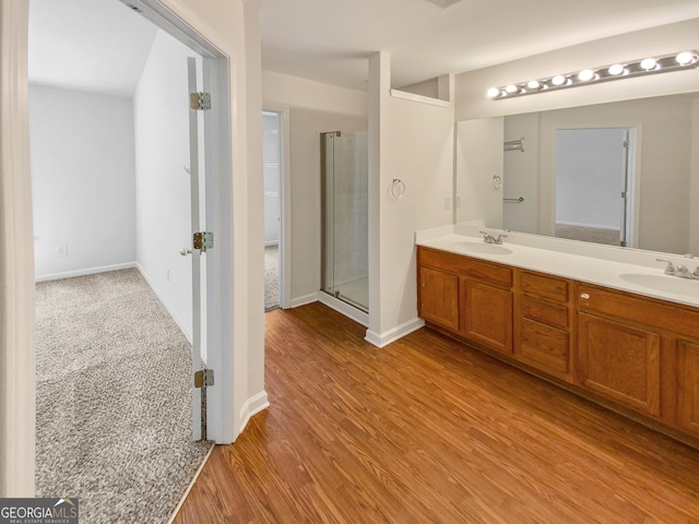 bathroom featuring walk in shower, double sink, wood-type flooring, and oversized vanity