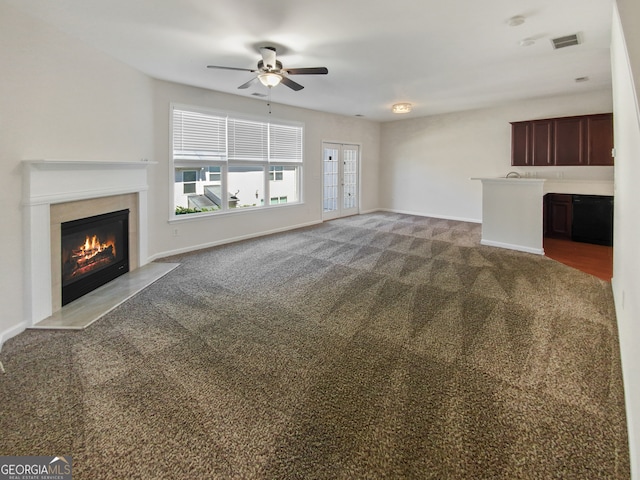 unfurnished living room with ceiling fan and dark carpet