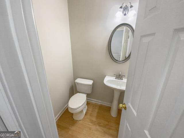 bathroom with hardwood / wood-style flooring and toilet