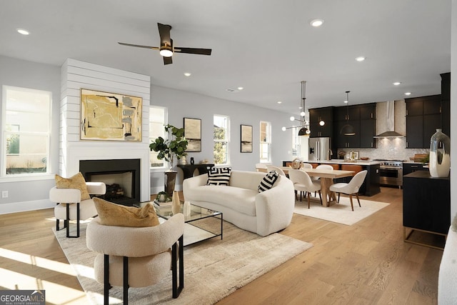 living room with ceiling fan and light hardwood / wood-style floors