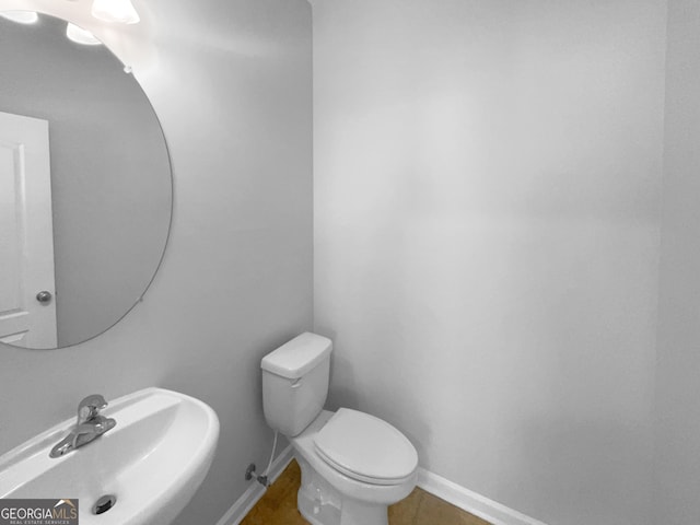 bathroom featuring tile flooring, sink, and toilet