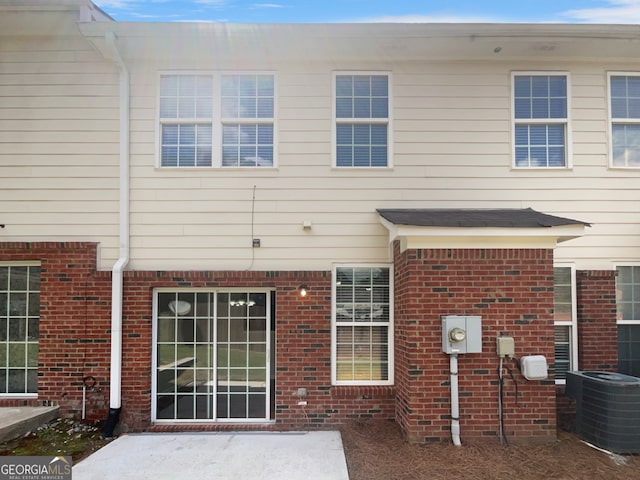 rear view of property featuring central AC unit and a patio