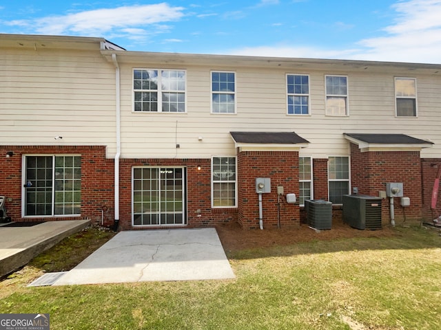 rear view of house featuring a patio, a yard, and central AC unit