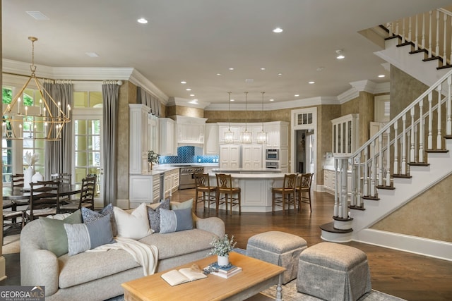 living room featuring ornamental molding, dark hardwood / wood-style floors, and a notable chandelier