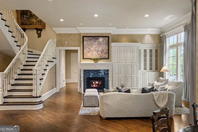 living room with hardwood / wood-style floors, ornamental molding, and a tiled fireplace