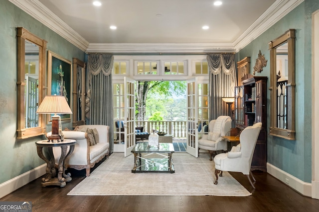 living area with hardwood / wood-style flooring and ornamental molding