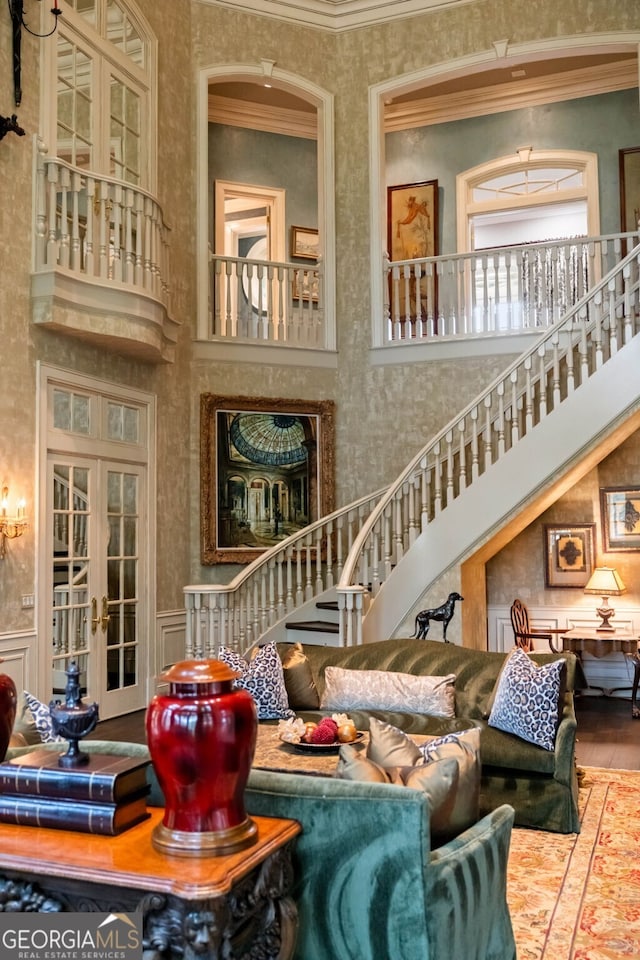 interior space featuring french doors, crown molding, a high ceiling, and hardwood / wood-style flooring