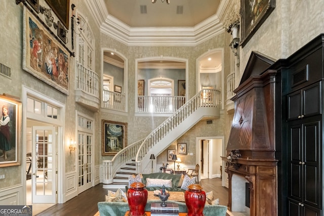 interior space featuring a high ceiling, crown molding, french doors, and hardwood / wood-style flooring