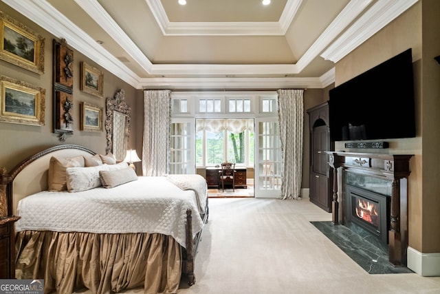 carpeted bedroom with a tray ceiling, access to outside, and ornamental molding