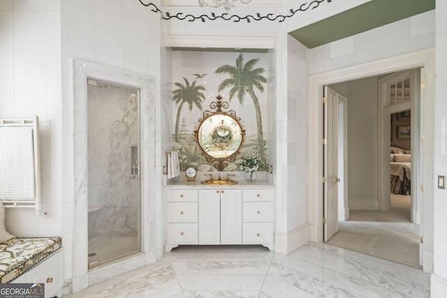 bathroom with tile walls, a shower with shower door, tile floors, and vanity with extensive cabinet space