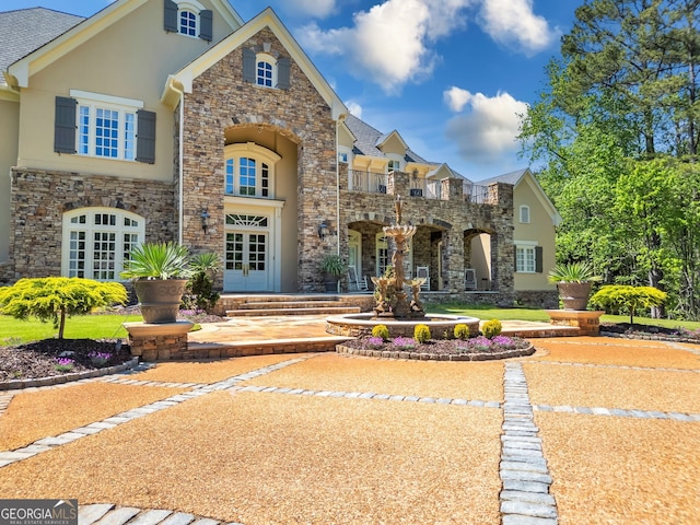 view of front of house with french doors and a balcony