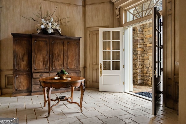 doorway with wood walls and a towering ceiling