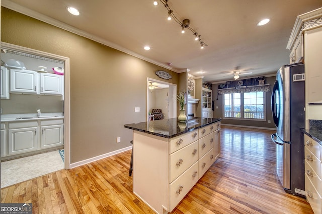 kitchen featuring white cabinets, light wood-type flooring, stainless steel fridge, ceiling fan, and track lighting