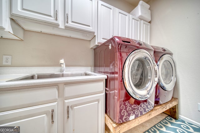 laundry area featuring cabinets, sink, and washer and clothes dryer