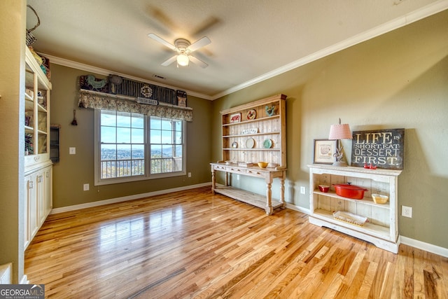 interior space featuring wood-type flooring, ceiling fan, and ornamental molding