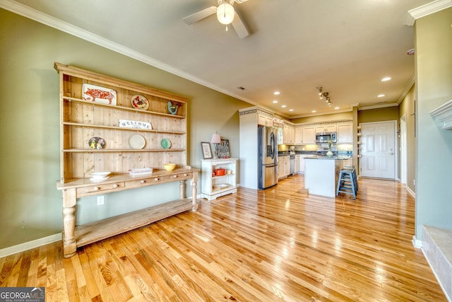 interior space featuring ceiling fan, crown molding, and light wood-type flooring