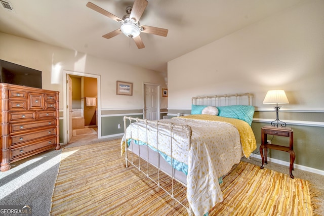 carpeted bedroom featuring ceiling fan and ensuite bathroom