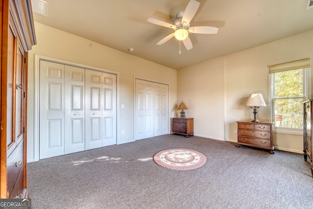 unfurnished bedroom with multiple closets, carpet floors, and ceiling fan