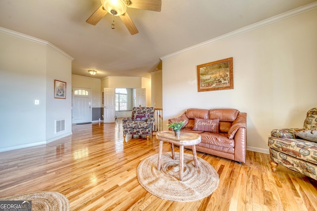 living room featuring ornamental molding, light hardwood / wood-style floors, and ceiling fan