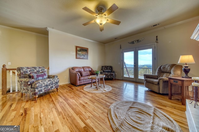 living room featuring french doors, ornamental molding, light hardwood / wood-style flooring, and ceiling fan