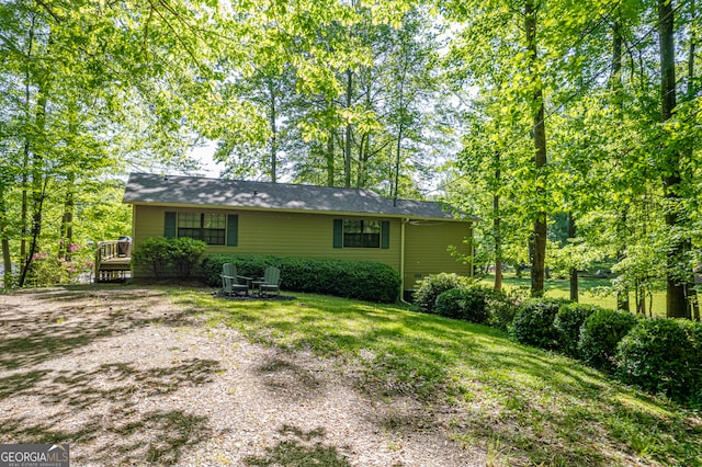 view of property exterior featuring a deck and a yard