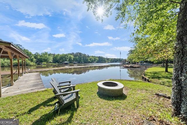 property view of water with a fire pit and a dock