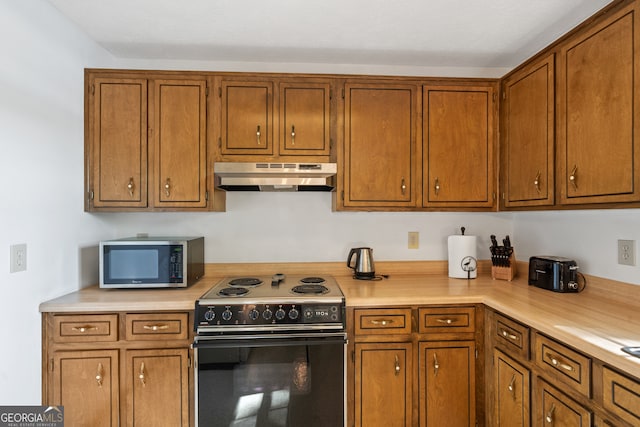 kitchen with black range with electric stovetop and wall chimney range hood