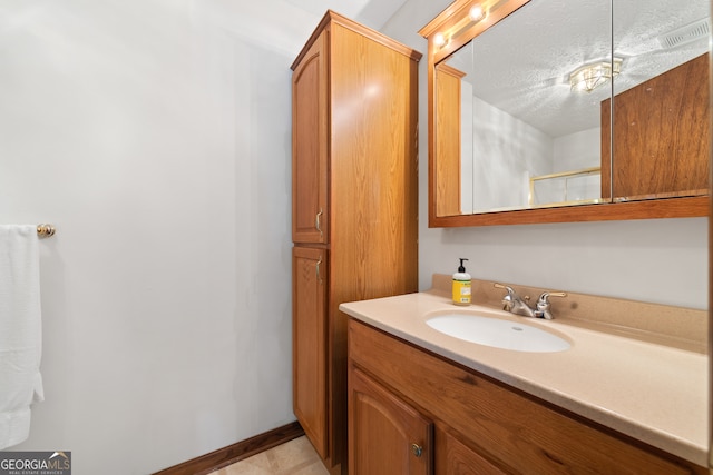 bathroom featuring a textured ceiling, large vanity, and tile floors