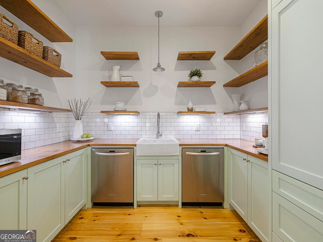 kitchen with stainless steel appliances, wall chimney range hood, white cabinetry, light hardwood / wood-style flooring, and a kitchen island