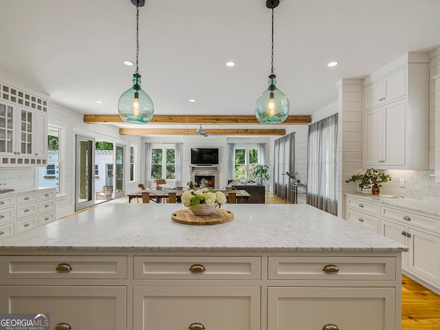 interior space featuring beamed ceiling, breakfast area, light hardwood / wood-style floors, and wooden walls