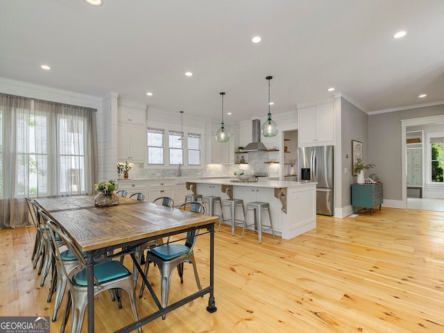 kitchen featuring pendant lighting, a kitchen island, light stone countertops, and light hardwood / wood-style floors