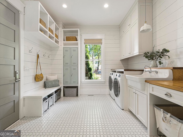 kitchen with light wood-type flooring, wall chimney exhaust hood, stainless steel appliances, white cabinets, and a center island