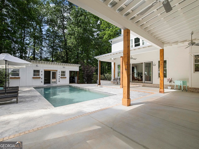 view of pool with ceiling fan, an outdoor structure, and a patio