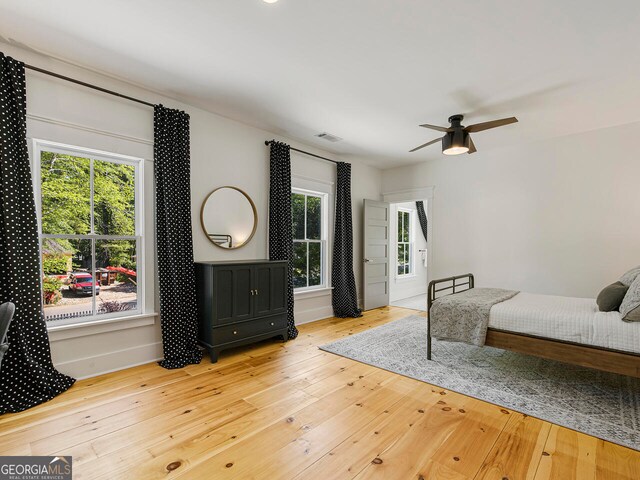 bedroom with ceiling fan, beamed ceiling, high vaulted ceiling, and hardwood / wood-style flooring