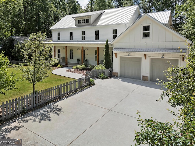 modern inspired farmhouse with a porch, a garage, and a front lawn