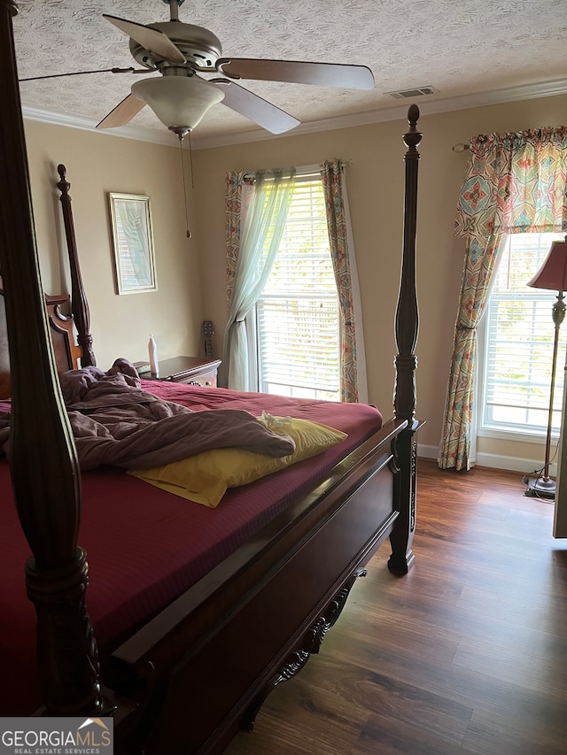 bedroom featuring crown molding, a textured ceiling, ceiling fan, and wood-type flooring