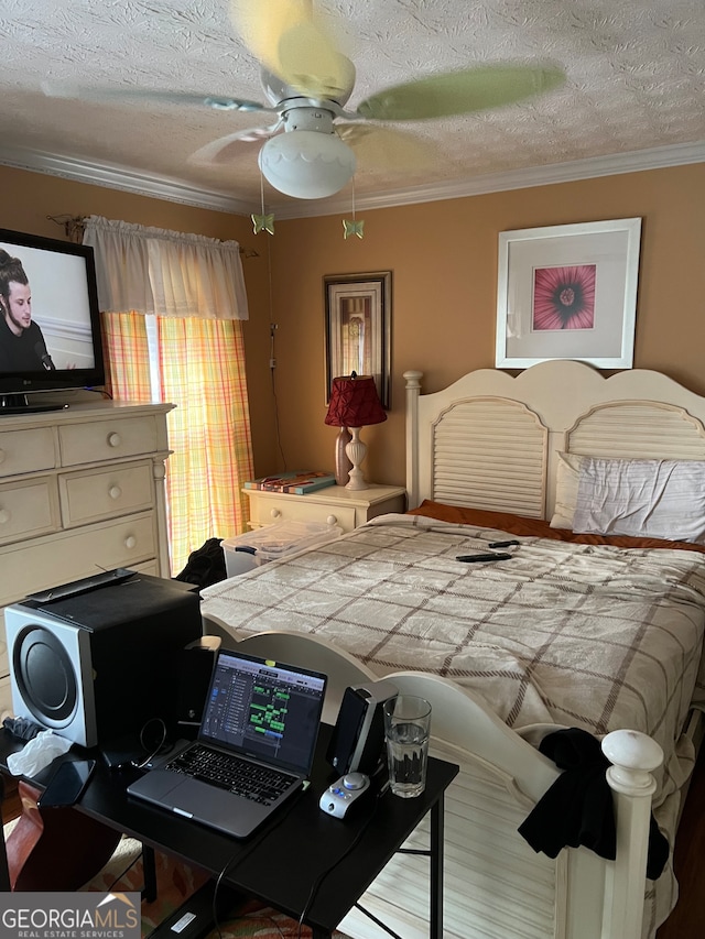 bedroom featuring ceiling fan, crown molding, and a textured ceiling