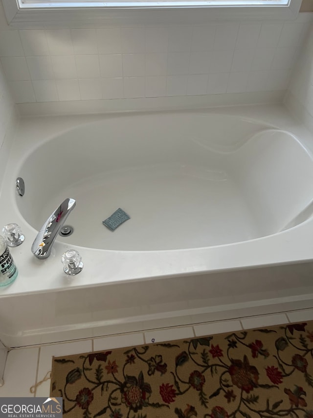 bathroom featuring tile patterned floors and a bath