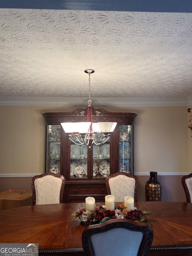 dining room featuring a notable chandelier, crown molding, and a textured ceiling